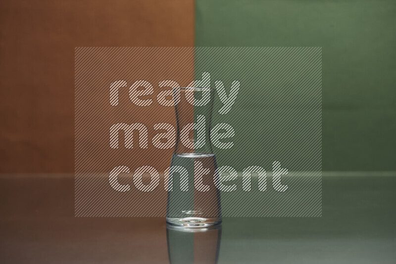 The image features a clear glassware filled with water, set against brown and dark green background