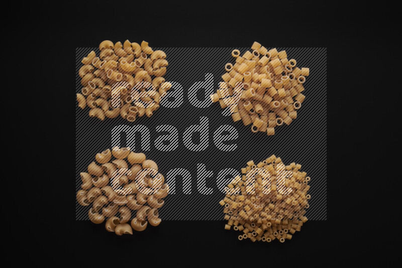 Different pasta types in bunches on black background