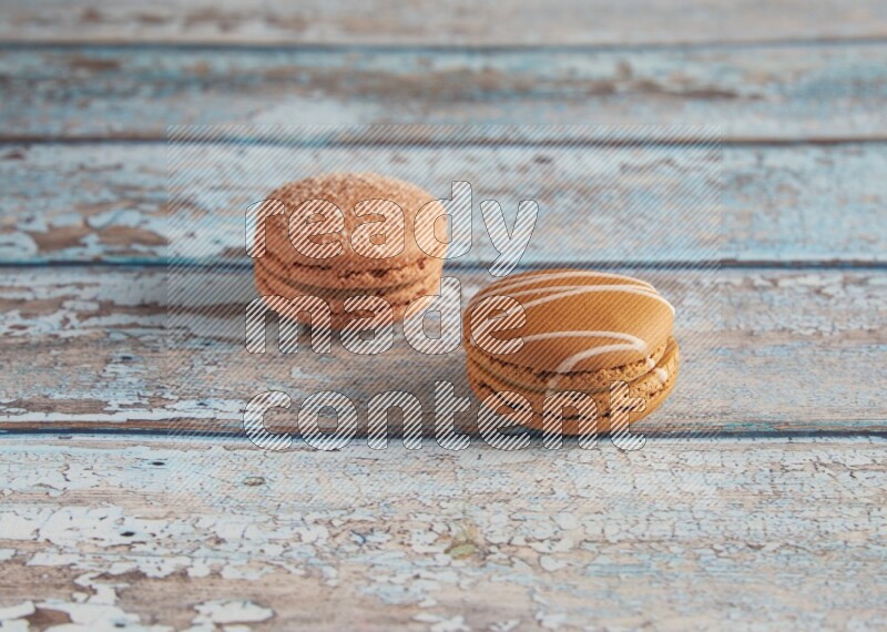 45º Shot of of two assorted Brown Irish Cream, and Brown Hazelnuts macarons  on light blue background
