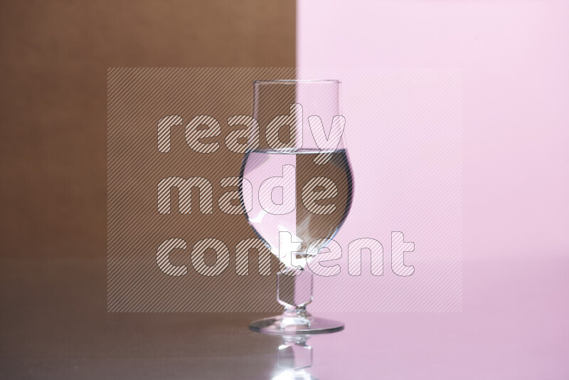The image features a clear glassware filled with water, set against brown and rose background