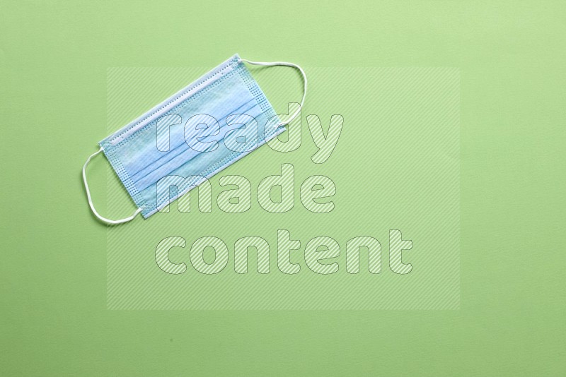 A face mask on green background (back to school)