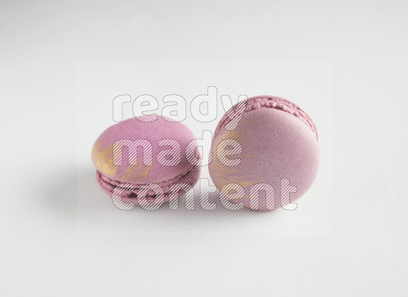 45º Shot of two Purple Strawberry macarons on white background