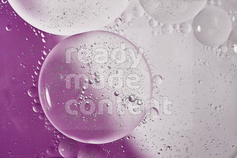 Close-ups of abstract oil bubbles on water surface in shades of white and purple