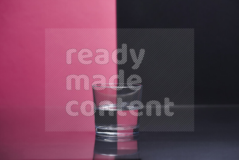 The image features a clear glassware filled with water, set against pink and black background