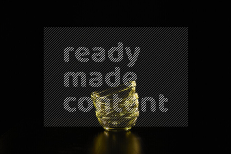 Glassware with rim light in yellow against black background