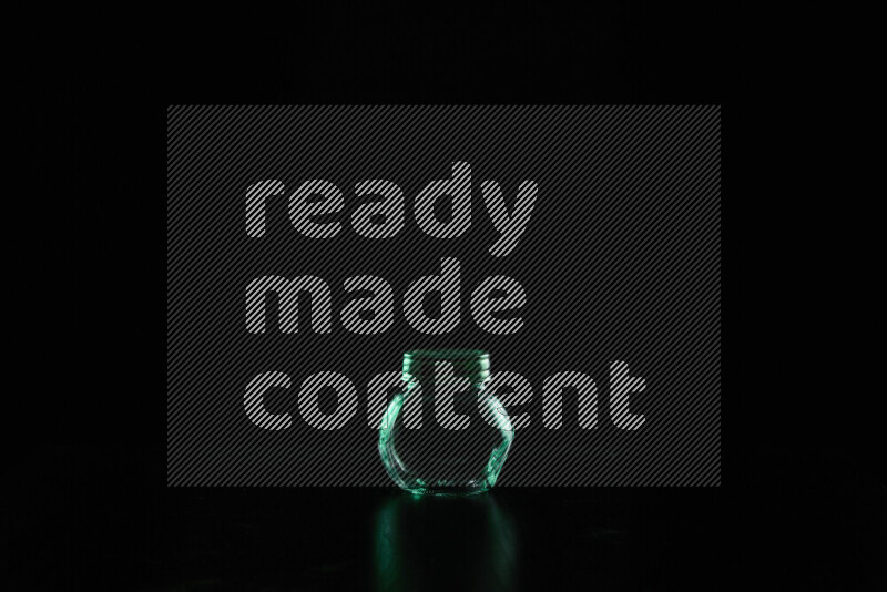 Glassware with rim light in green against black background