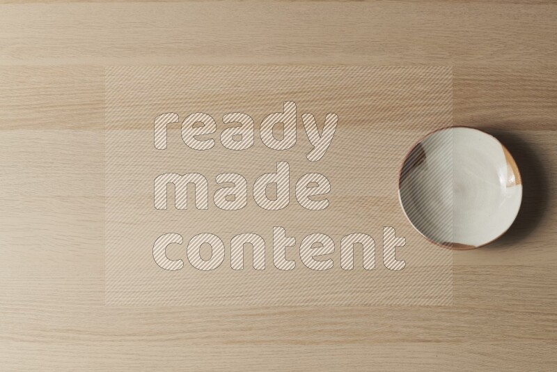 A multicolored pottery plate on light wooden background