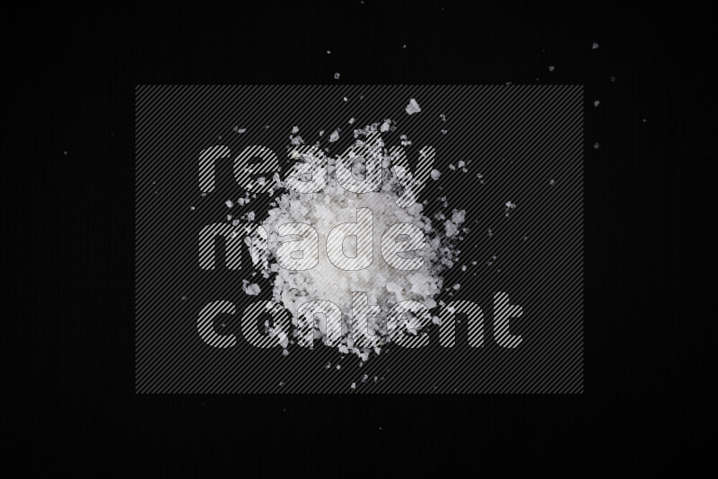 A bunch of coarse sea salt crystals on black background