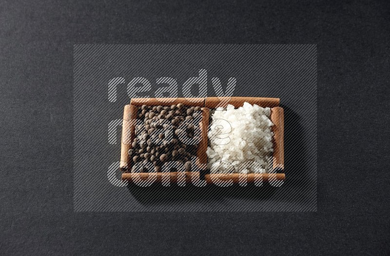 2 squares of cinnamon sticks full of white salt and allspice on black flooring