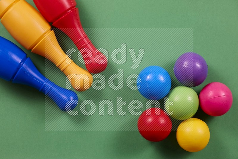 Plastic bowling pins with balls on different background in top view (kids toys)
