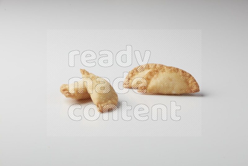 Four fried sambosas on a white background