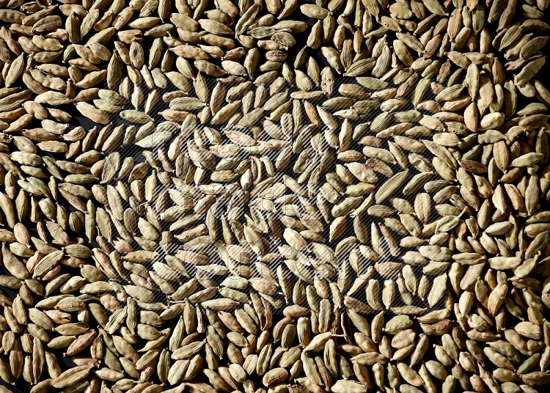 Cardamom seeds filling the frame on black flooring