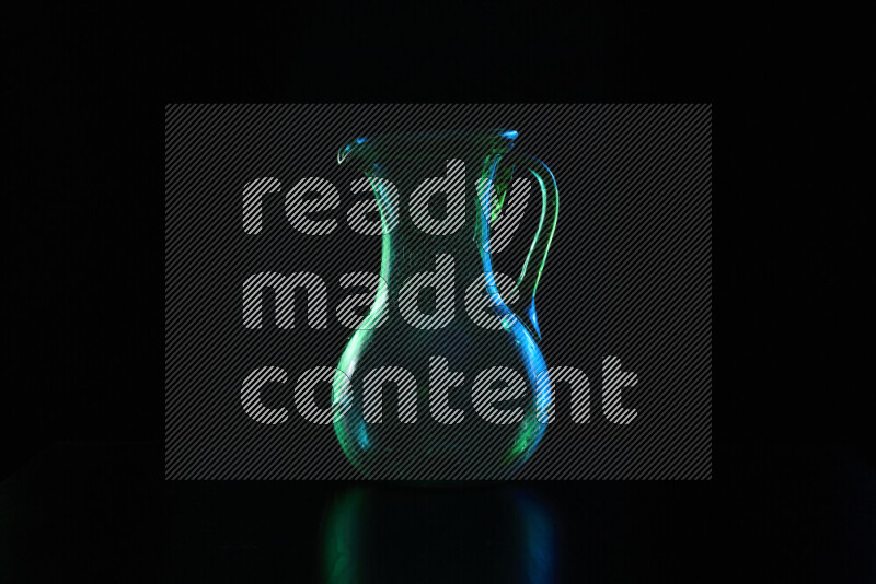 Glassware with rim light in blue and green against black background