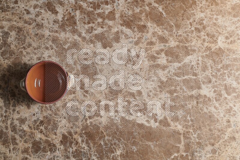 A multicolored pottery pot on beige marble background