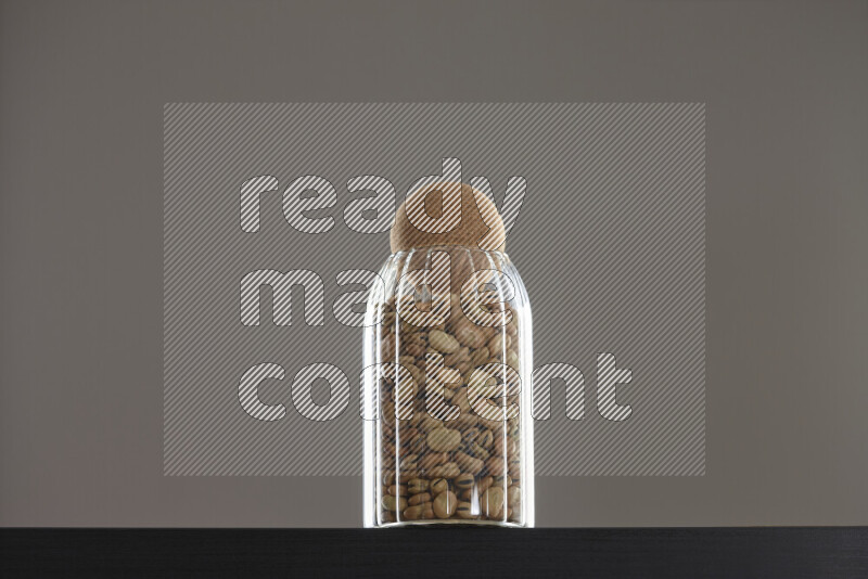 Fava beans in a glass jar on black background