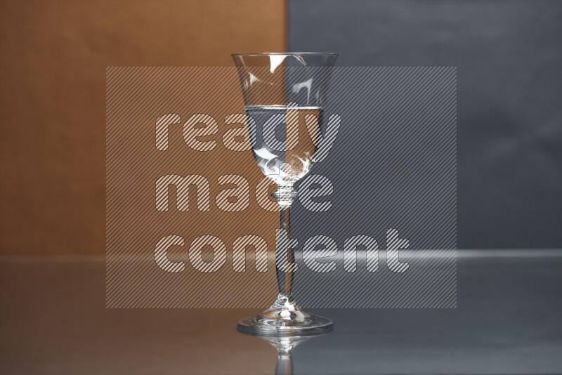 The image features a clear glassware filled with water, set against brown and dark blue background