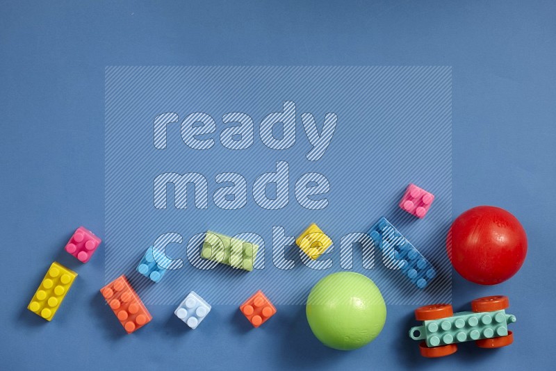 Plastic building blocks with balls on blue background in top view (kids toys)