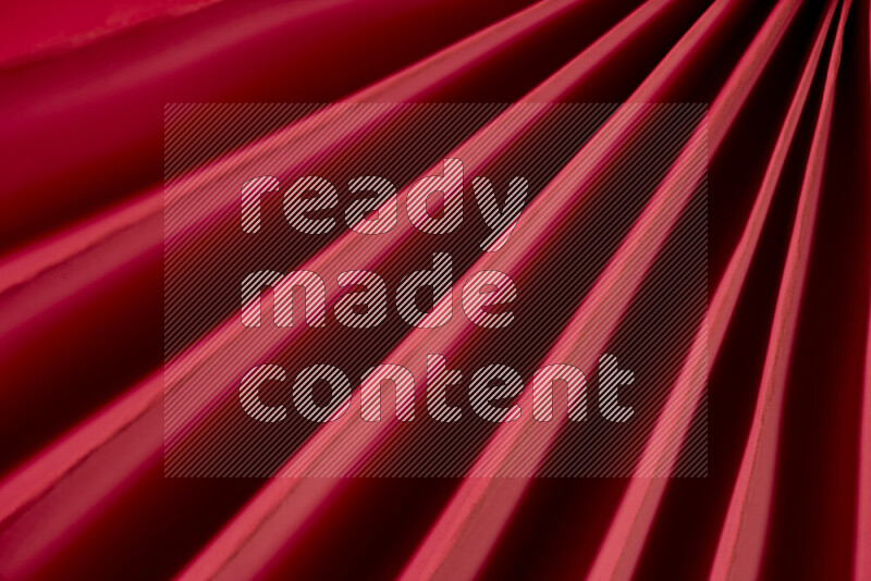 An image presenting an abstract paper pattern of lines in red tones