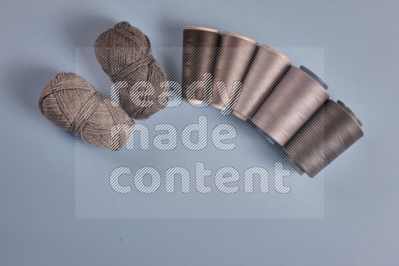 مجموعة من أدوات الخياطة والتفصيل رمادية اللون على خلفية زرقاء