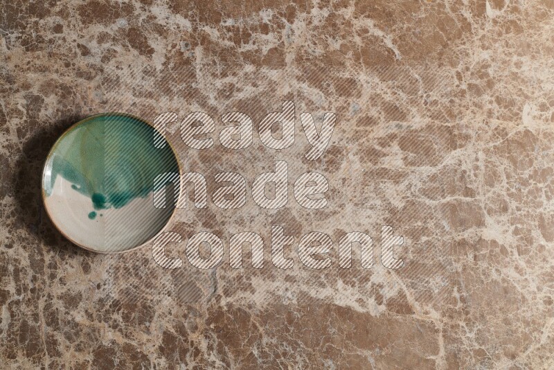 A decorative pottery plate on beige marble background