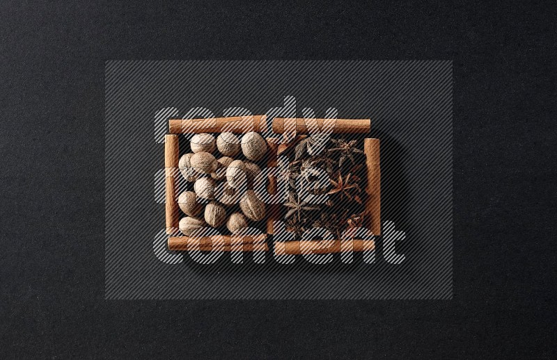 2 squares of cinnamon sticks full of nutmeg and star anise on black flooring