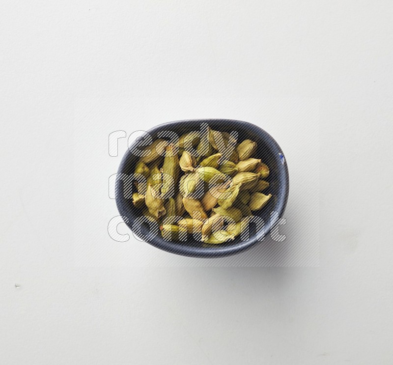 Top-view shot of Cardamon in a container on white background