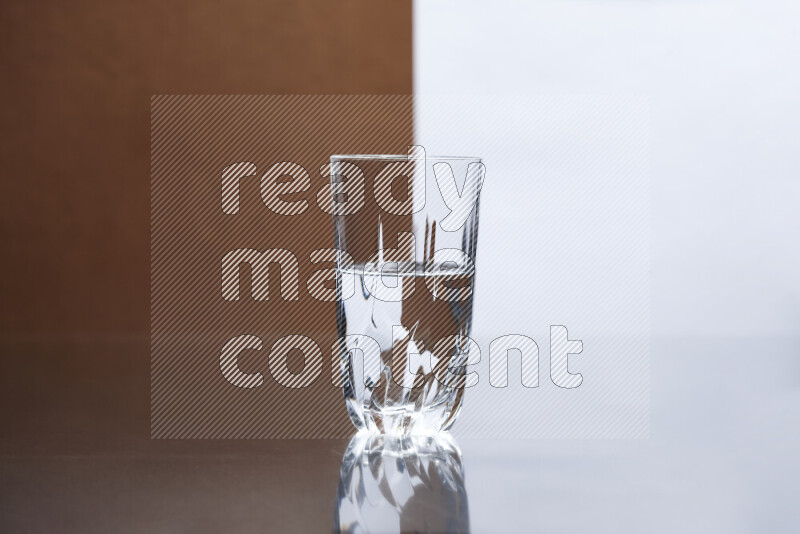 The image features a clear glassware filled with water, set against white and brown background