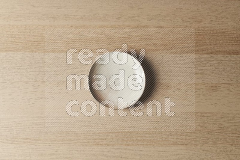 Top View Shot Of A Beige Pottery Plate on Oak Wooden Flooring