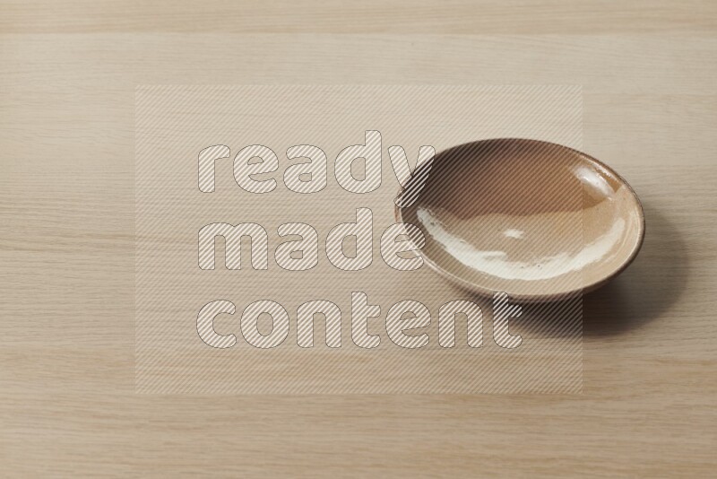 A multicolored pottery plate on light wooden background
