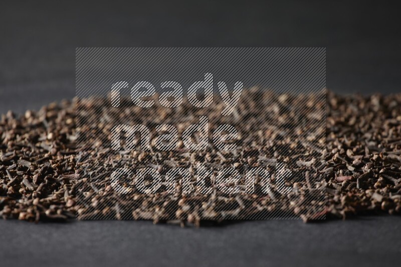 Cloves spread on black flooring