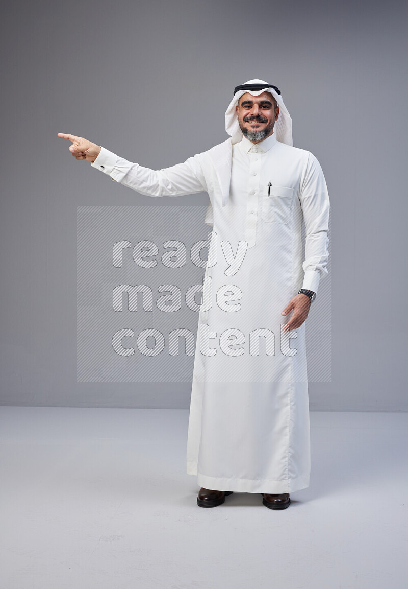 رجل سعودي يرتدي ثوب وشماغ ابيض يتفاعل امام الكاميرا