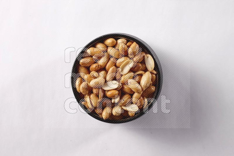 Peanuts in a black pottery bowl on white background
