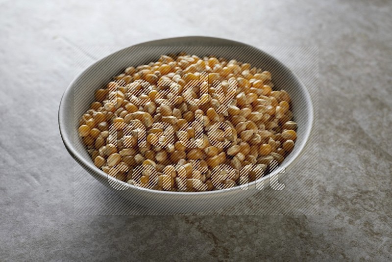 corn kernel in a gray ceramic bowl on a grey textured countertop