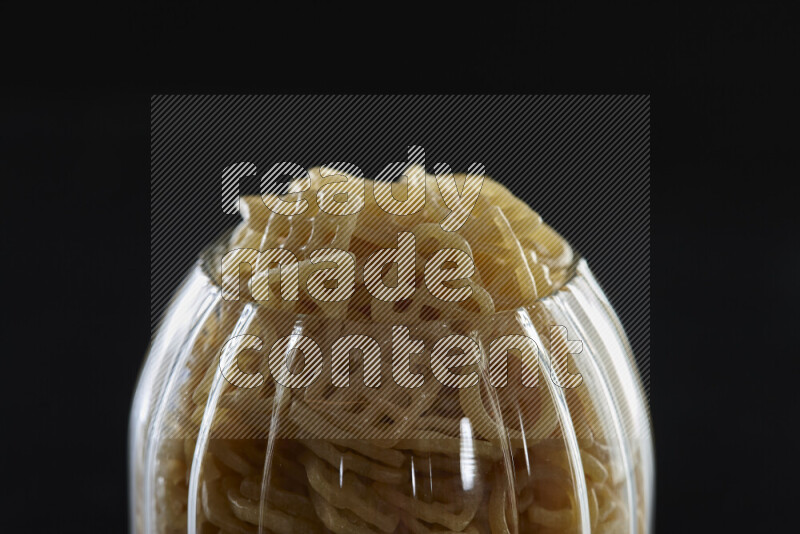 Snacks in a glass jar on black background