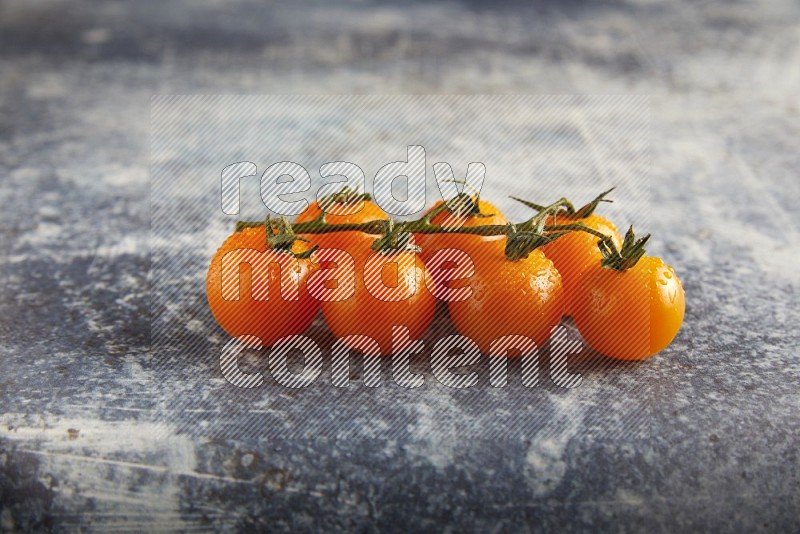 Orange cherry tomato vein on a textured rusty blue background 45 degree