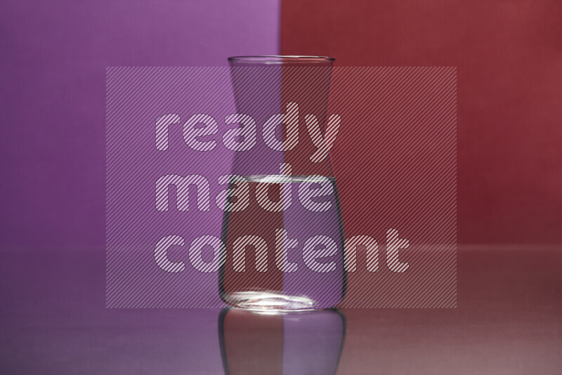 The image features a clear glassware filled with water, set against purple and dark red background