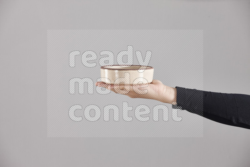 A woman in black abaya holding different pottery essentials in different positions