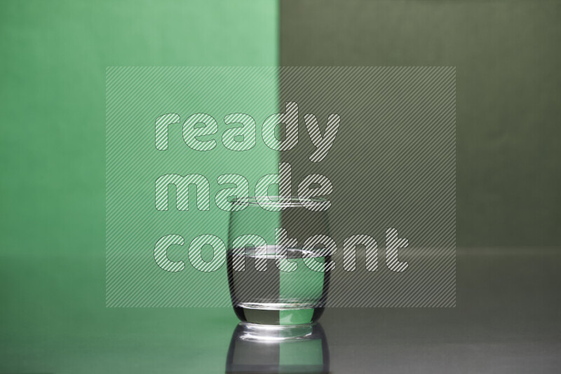 The image features a clear glassware filled with water, set against green and dark green background