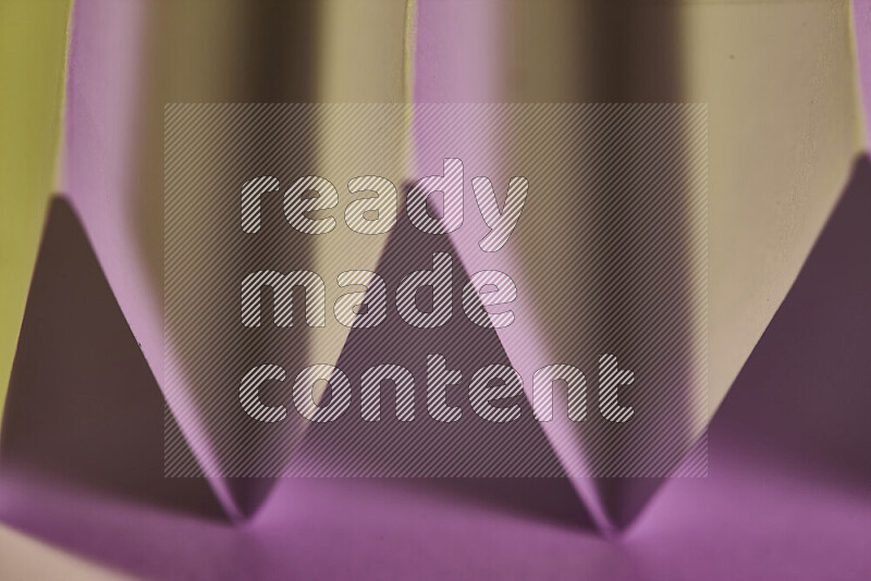 صورة مجردة مقربة تظهر طيات ورقية هندسية حادة بتدرجات اللون الوردي مع درجات لونية دافئة