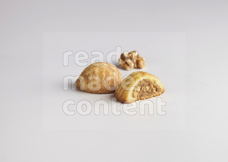 Two Pieces of Maamoul filled with walnut paste  one of them is cut direct on white background