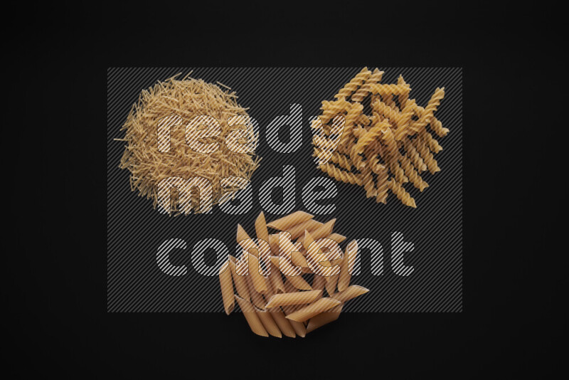 Different pasta types in bunches on black background