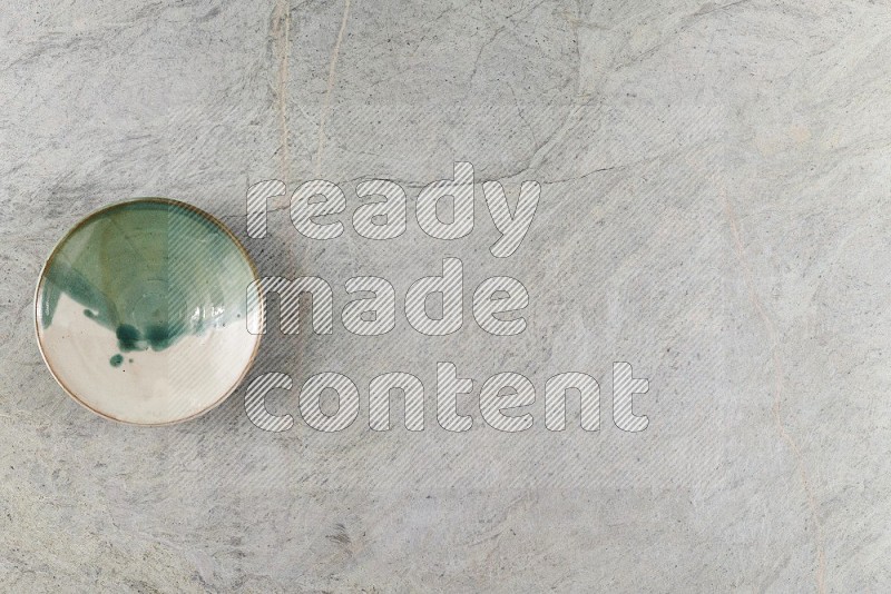 Top View Shot Of A Multicolored Pottery Bowl On Grey Marble Flooring