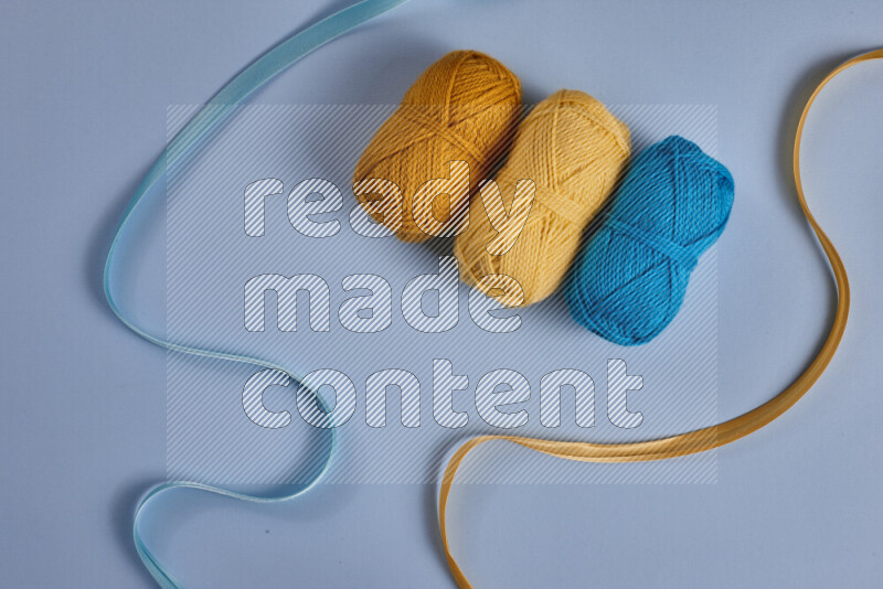 A yellow and blue collection of sewing and tailoring tools arranged on a blue background
