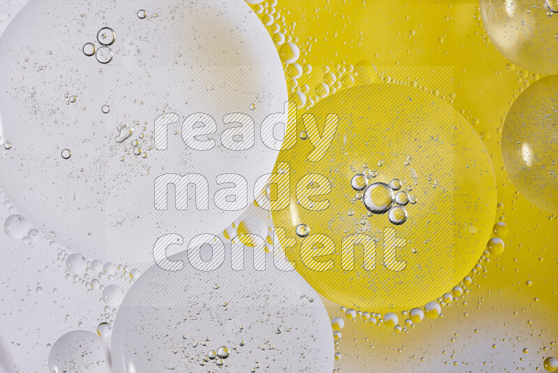 Close-ups of abstract oil bubbles on water surface in shades of white and yellow