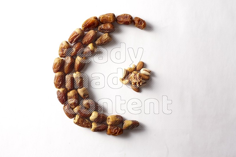 Dates in a crescent shape with nuts on white background