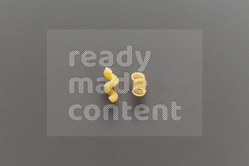 Twist pasta with other types of pasta on grey background