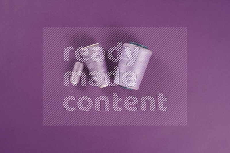 مجموعة من أدوات الخياطة والتفصيل أرجوانية اللون على خلفية أرجوانية