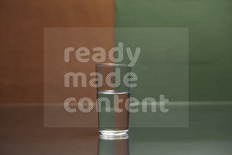 The image features a clear glassware filled with water, set against brown and dark green background