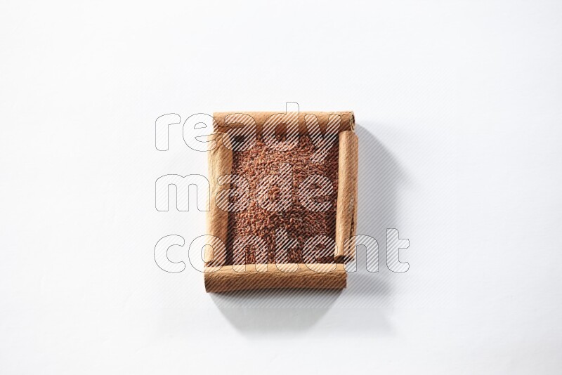 A single square of cinnamon sticks full of garden cress on white flooring