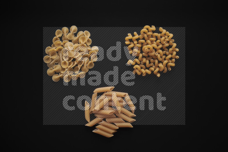 Different pasta types in bunches on black background